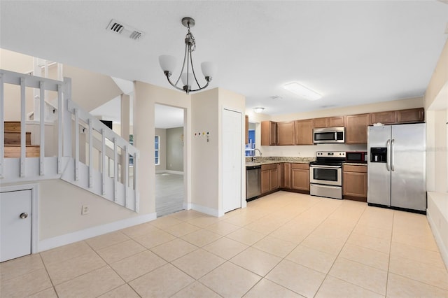 kitchen featuring visible vents, baseboards, brown cabinets, appliances with stainless steel finishes, and light tile patterned floors