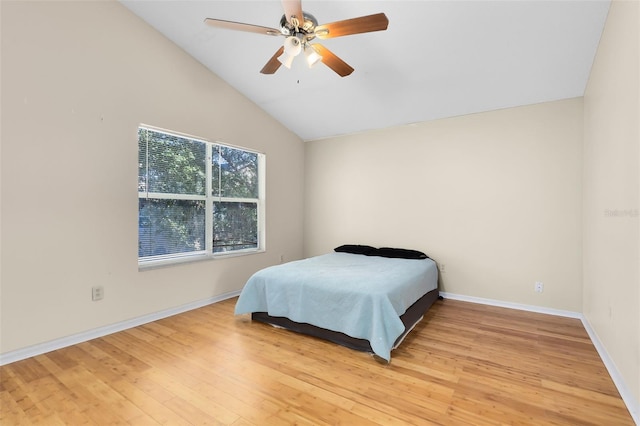 bedroom with baseboards, a ceiling fan, vaulted ceiling, and light wood-style flooring