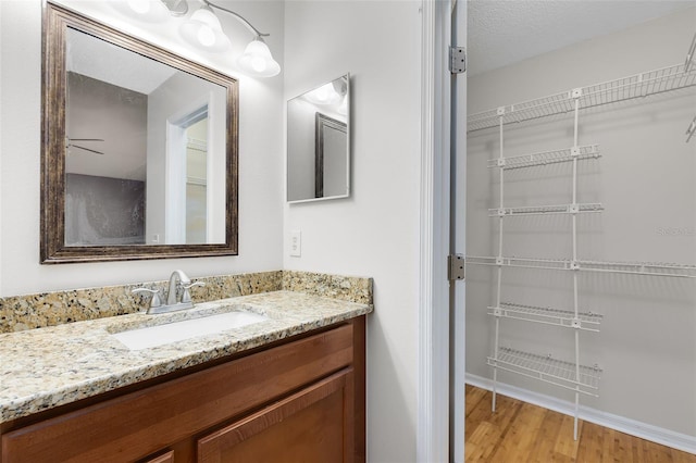 bathroom featuring vanity, baseboards, and wood finished floors