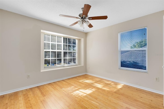 empty room featuring baseboards, a healthy amount of sunlight, and hardwood / wood-style floors