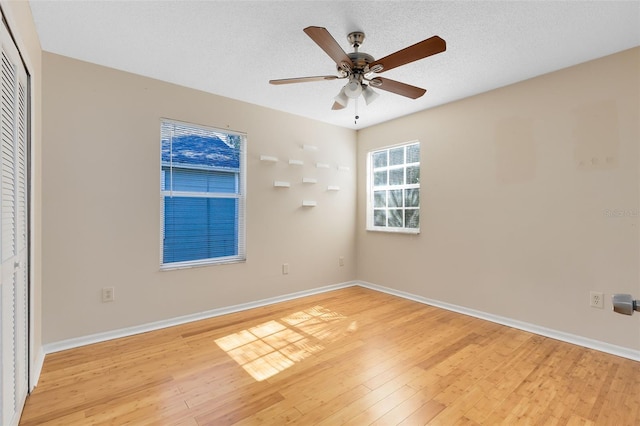unfurnished room with baseboards, a ceiling fan, and light wood finished floors