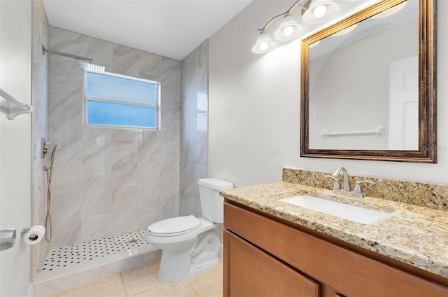 full bathroom featuring toilet, a tile shower, tile patterned flooring, and vanity
