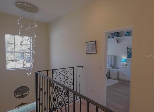 hall featuring wood-type flooring and a notable chandelier