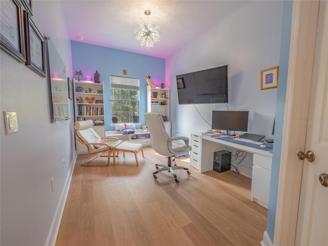 office space featuring light wood-type flooring, an inviting chandelier, and vaulted ceiling