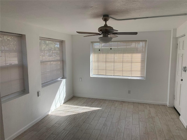 unfurnished room featuring ceiling fan, light hardwood / wood-style flooring, and a textured ceiling