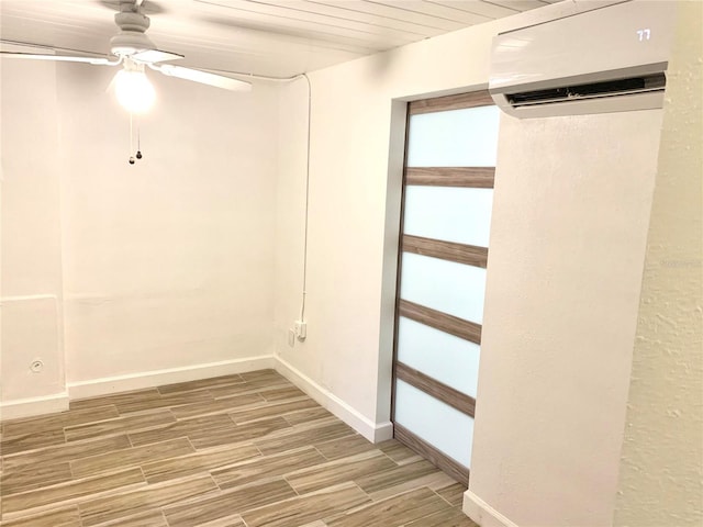 basement with wood-type flooring, a wall unit AC, ceiling fan, and wooden ceiling