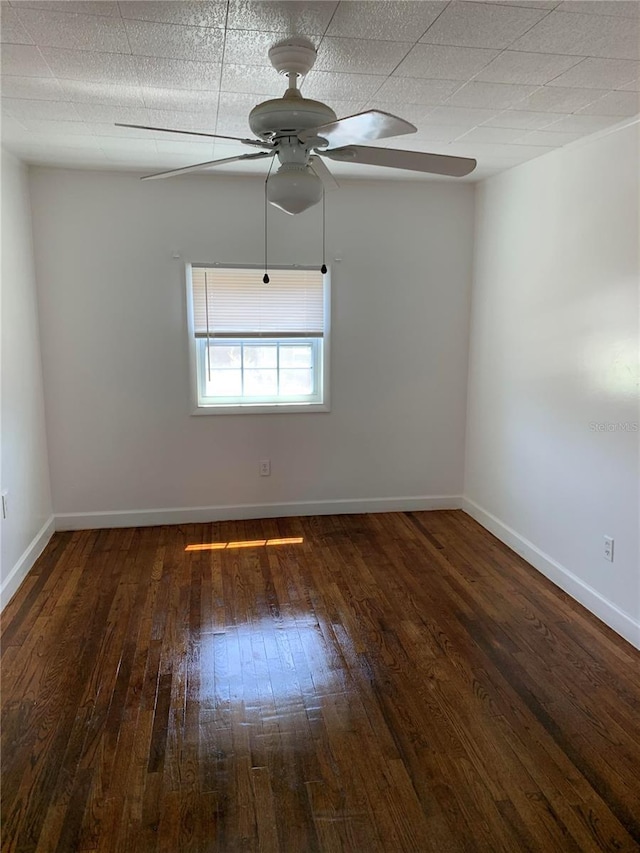 empty room featuring ceiling fan and dark hardwood / wood-style flooring