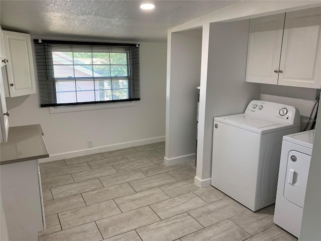 laundry room featuring cabinets, independent washer and dryer, and a textured ceiling