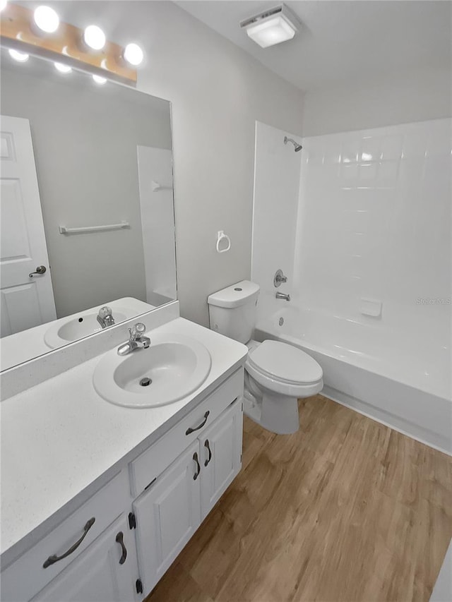 full bathroom with vanity, wood-type flooring, bathtub / shower combination, and toilet