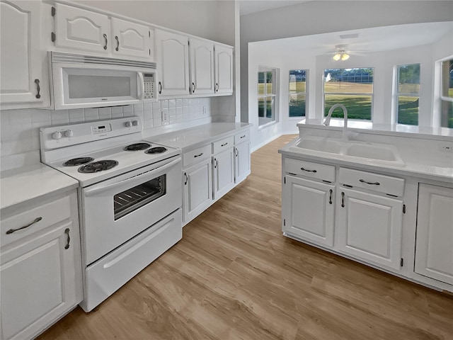 kitchen with white cabinetry, sink, light hardwood / wood-style floors, white appliances, and decorative backsplash