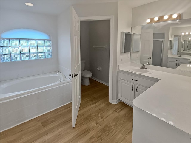 full bathroom with vanity, hardwood / wood-style flooring, toilet, and independent shower and bath