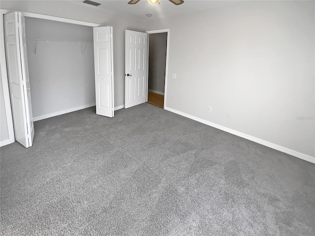 unfurnished bedroom with dark colored carpet, ceiling fan, and a closet