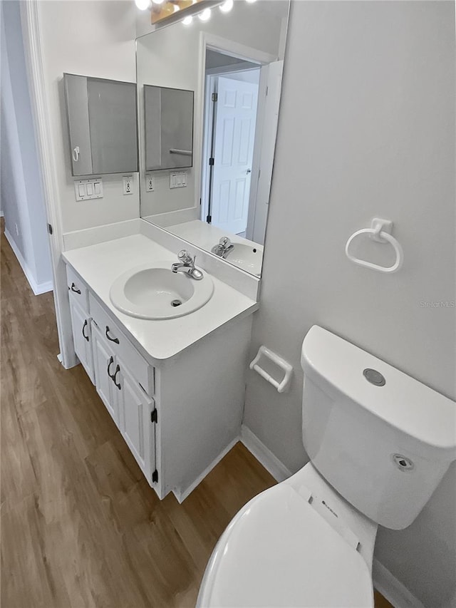 bathroom featuring hardwood / wood-style floors, vanity, and toilet