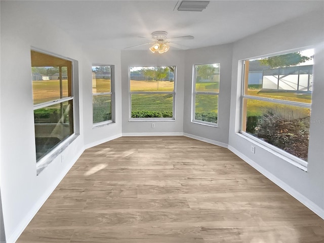 unfurnished sunroom featuring ceiling fan