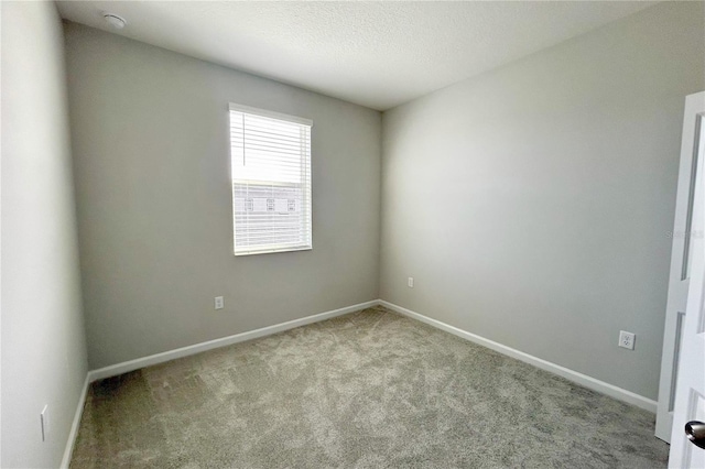 unfurnished room featuring light carpet and a textured ceiling