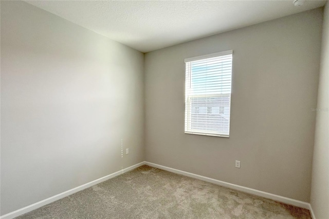 carpeted empty room featuring a textured ceiling