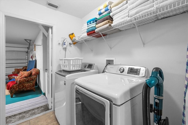 laundry area with light tile patterned floors and independent washer and dryer