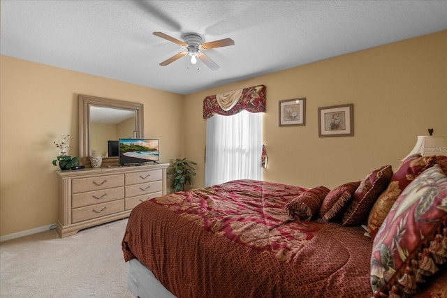 carpeted bedroom featuring a textured ceiling and ceiling fan