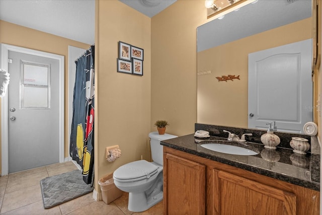 bathroom with tile patterned flooring, vanity, and toilet