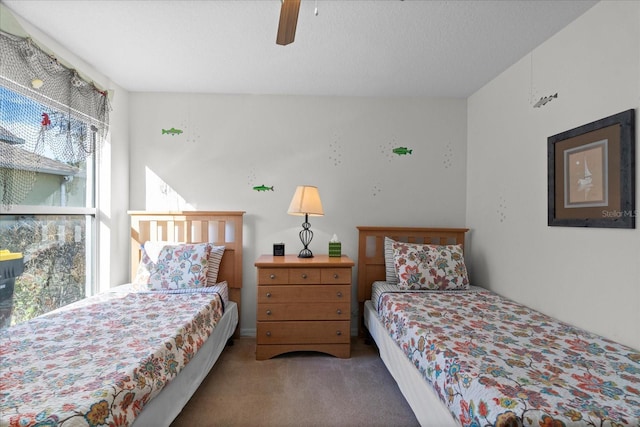 bedroom with carpet flooring, ceiling fan, and a textured ceiling