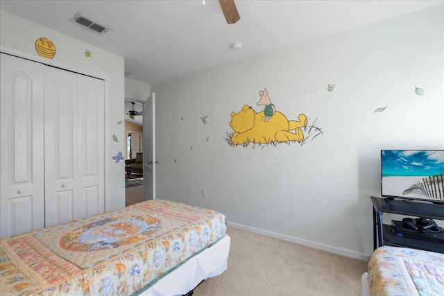 bedroom with ceiling fan, a closet, and light colored carpet