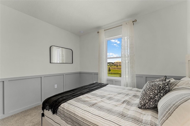 bedroom featuring a textured ceiling and light colored carpet