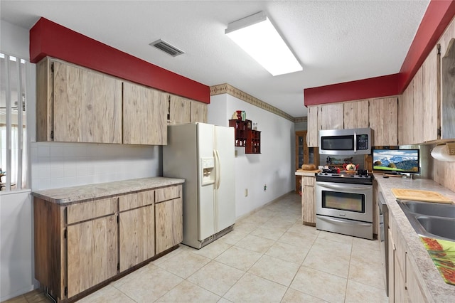 kitchen featuring decorative backsplash, ornamental molding, a textured ceiling, and appliances with stainless steel finishes