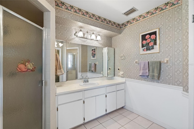 bathroom featuring tile patterned flooring, vanity, and a shower with door