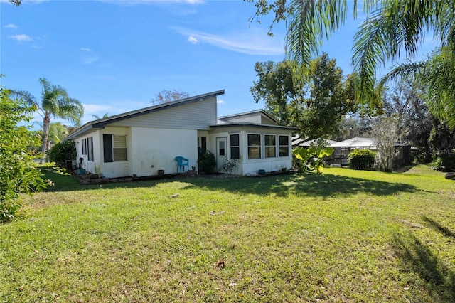 back of house with a lawn