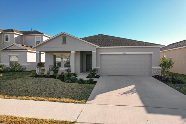 view of front of home with a porch, a garage, and a front lawn