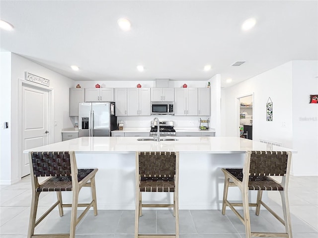 kitchen with a kitchen breakfast bar, a large island, sink, and stainless steel appliances