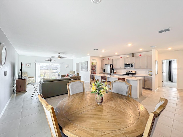 dining space featuring light tile patterned floors, ceiling fan, and sink