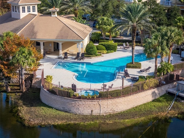 view of pool featuring a water view and a patio area