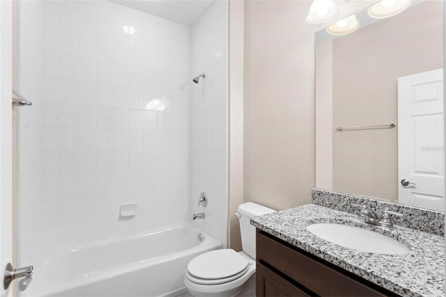 full bathroom with tiled shower / bath, vanity, and toilet