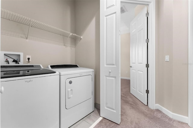 clothes washing area with light carpet and independent washer and dryer