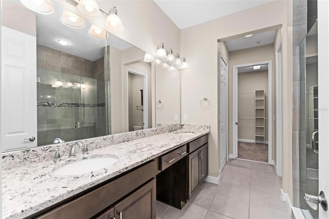 bathroom with vanity, tile patterned floors, a shower with door, and toilet