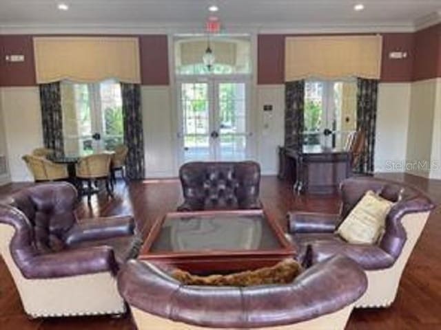 living room with dark hardwood / wood-style flooring, crown molding, and french doors