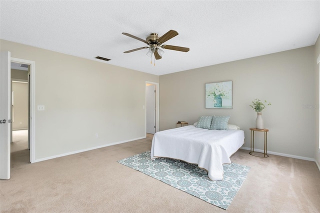 carpeted bedroom featuring a textured ceiling and ceiling fan