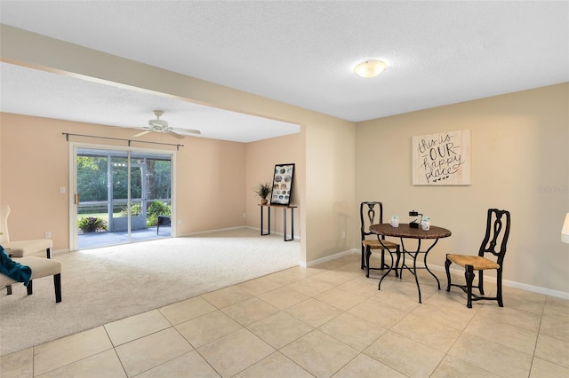 carpeted dining area with ceiling fan and a textured ceiling