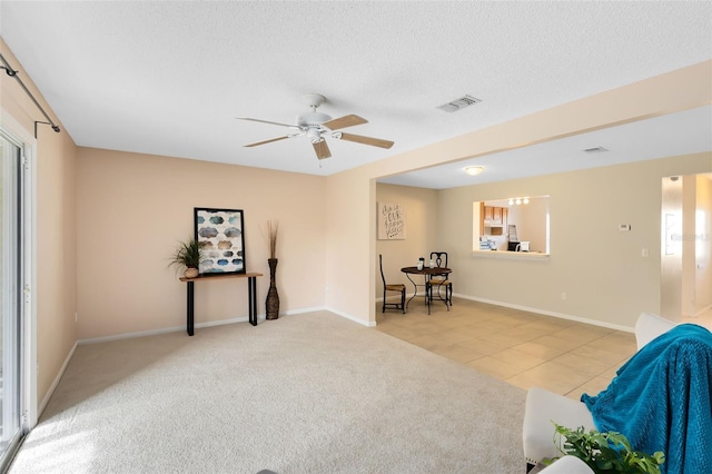 living area with ceiling fan and light tile patterned flooring