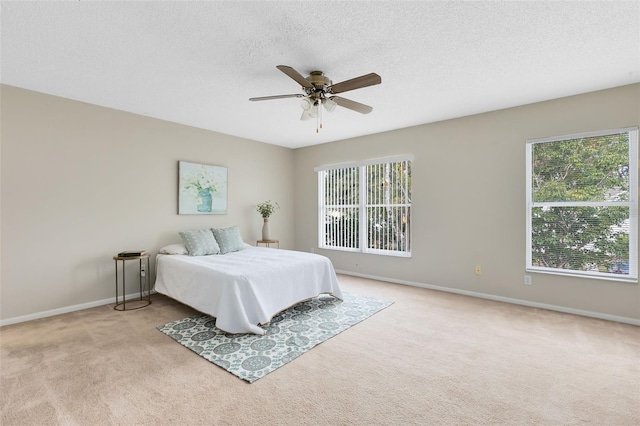 carpeted bedroom with a textured ceiling and ceiling fan