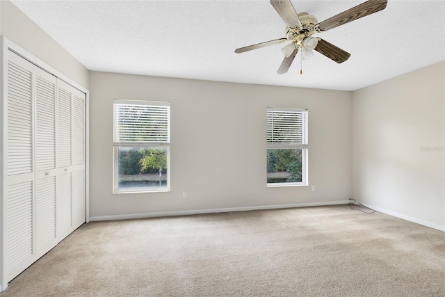 unfurnished bedroom featuring light carpet, a closet, and ceiling fan