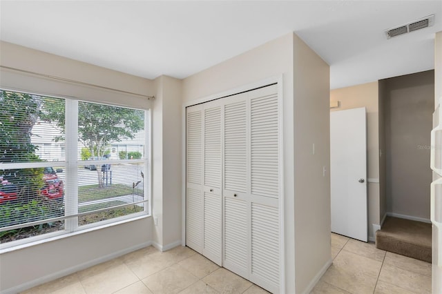 interior space with a closet and light tile patterned floors