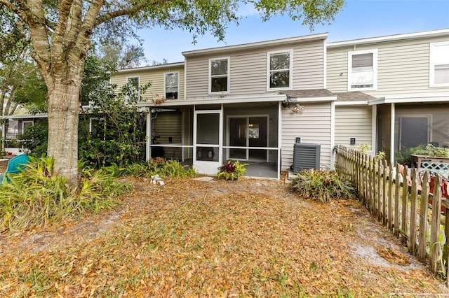 rear view of house with central AC and a sunroom