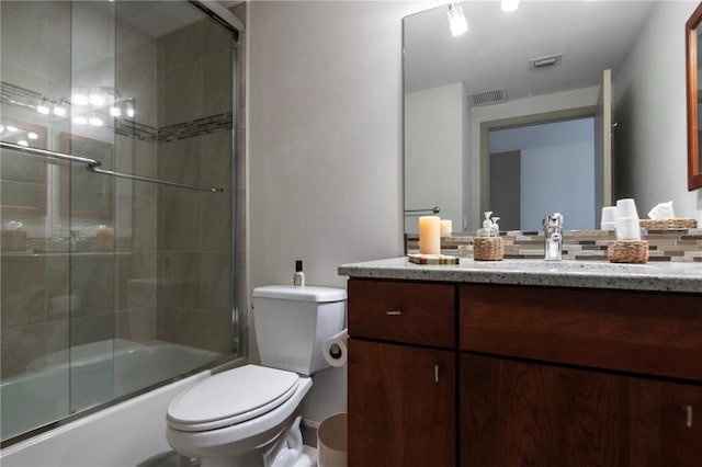 full bathroom with vanity, toilet, and shower / bath combination with glass door