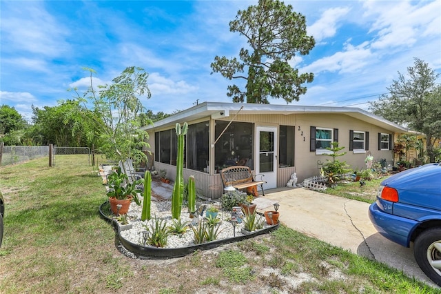 back of house featuring a sunroom and a yard