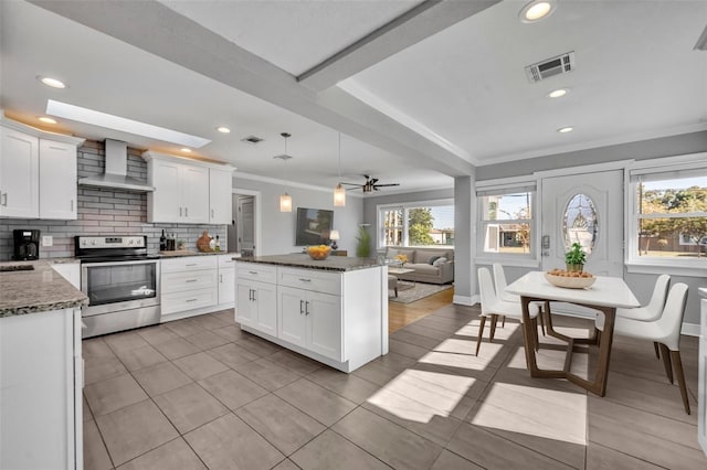 kitchen featuring electric range, wall chimney exhaust hood, and white cabinetry