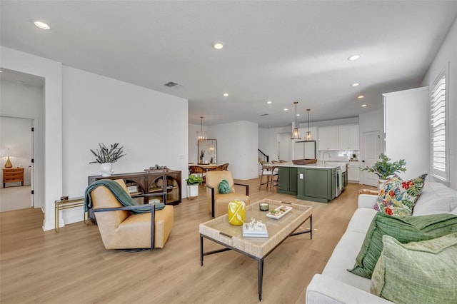 living room with light wood-type flooring and sink