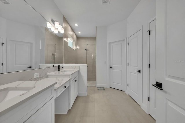 bathroom with a tile shower, tile patterned flooring, and vanity