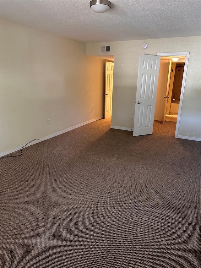 carpeted spare room with a textured ceiling